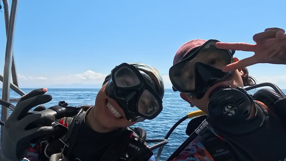 Two Ocean Gardener divers smiling on the boat before a dive